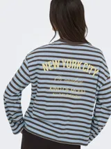 Remera de manga larga a rayas horizontales en tonos marrón y tostado, con cuello redondo y el texto "vibrant studio" estampado en el pecho.