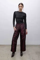 Top negro de mangas largas con frunces en el hombro izquierdo.