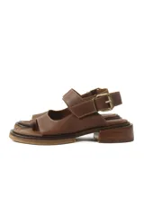 Sandalias de cuero marrón con diseño de punta abierta, tiras ajustables con hebilla metálica y suela de bloque bajo.