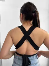 Top negro con escote halter y tiras cruzadas en el abdomen.