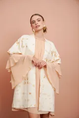 Vestido corto de manga larga acampanada con volados en cascada, color salmón claro, de corte suelto y escote redondo.