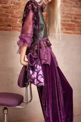 Cartera de mano tipo bolsa confeccionada en terciopelo de seda color violeta, con bordado floral en hilo dorado y detalle de borlas colgantes.