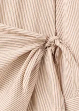 Blusa de lyocell y viscosa con estampado de rayas finas, cuello redondo, manga larga abotonada y detalle cruzado en la cintura.