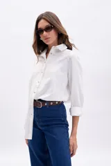 Camisa blanca de manga larga con cuello camisero y pespuntes contrastantes en color crudo.