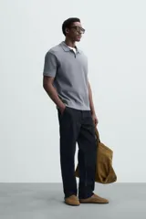 Polo de manga corta color verde oliva, con cuello solapa y abertura frontal tipo polo. Presenta una textura acanalada vertical y un calce regular.