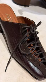 Zapatos destalonados de cuero en combinación marrón y negro con textura de cocodrilo, cordones negros, puntera cuadrada y taco geométrico de madera.