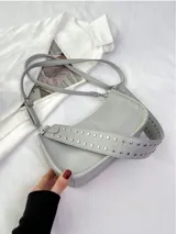 Cartera baguette color borgoña con correa corta con tachas plateadas.