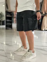 Bermuda cargo de jean color beige, con bolsillos laterales con solapa en las piernas y corte holgado.