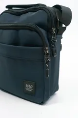 Morral de diseño compacto en color azul marino, con múltiples compartimentos con cierre, manija superior y correa ajustable para llevar al hombro. Incluye etiqueta con logo de la marca en la parte frontal.