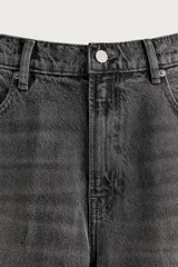 Pantalón de jean corte slim fit, color azul oscuro, con diseño de cinco bolsillos, tiro medio y cierre frontal con cremallera y botón.