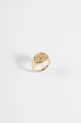 Anillo de acero quirúrgico dorado, tipo sello con un relieve en forma de corazón en el centro.
