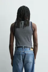 Camiseta sin mangas de corte regular, confeccionada en tejido de algodón con elasticidad. Presenta un diseño de rayas horizontales finas, cuello redondo y acabados en vivo doble.