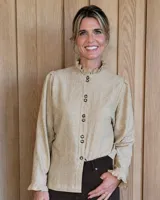 Camisa de manga larga con estampado a cuadros en tonos verde oscuro y beige. Presenta cuello alto con volados, cierre frontal con botones y puños con volados elásticos.