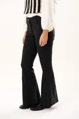 Pantalón de vestir negro de corte acampanado, con cintura de tiro medio, cierre frontal con botón y bolsillos laterales.