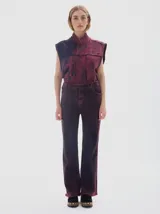 Pantalón de jean de mujer, corte flare con tiro medio, teñido en color bordeaux con efecto lavado y desgaste en las costuras.