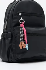 Mochila pequeña color beige de cuero sintético, con múltiples bolsillos frontales y laterales con cierre. Tiene tiradores con cordones de colores y correas regulables.