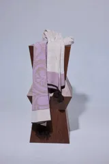 Chal de lana con diseño de patrón paisley y detalles de tejido en punto. Presenta terminaciones con pompones en los extremos.