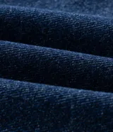 Pantalón wide leg de jean color azul oscuro con diseño de tiro alto, pernera amplia y recta, bolsillos estilo five pockets y cierre frontal con botón y cremallera.