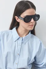 Camisa de manga larga de algodón en color blanco, con cuello clásico, cierre frontal de botones y silueta relajada.