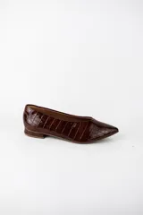 Zapatos planos estilo chatitas marca Marí, modelo Rita, color negro con textura efecto cocodrilo y acabado charol. Tienen punta fina y un diseño clásico de corte bajo.