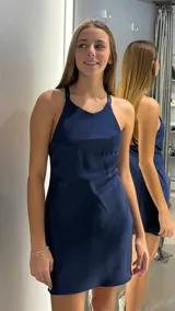 Vestido corto de satén color azul marino, con escote halter y espalda descubierta con tiras cruzadas.