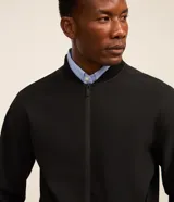 Campera estilo bomber de color negro, confeccionada con tejido repelente al agua. Posee cuello semi alto, cierre frontal con cremallera, bolsillos laterales y puños y dobladillo elastizados. Marca Marfinno.