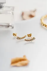 Aros tipo ear climber dorados con circonias blancas.