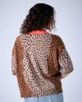 Polo de cashmere con estampado animal, corte oversize, mangas cortas, cuello escote en V, cierre de botón y bordes acanalados.