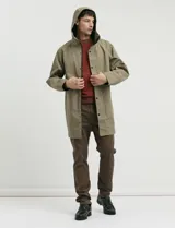 Gabardina con capucha de corte recto y largo medio. Cuenta con cierre frontal engomado, cartera con botones a presión, bolsillos laterales y tejido repelente al agua y al viento.