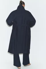 Abrigo de paño confeccionado en mezcla de lana, color azul marino. Presenta cuello solapa, manga larga, cierre frontal con botones y bolsillos delanteros. Incluye un cinturón del mismo tejido para ajustar a la cintura.