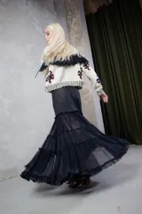 Falda midi de tul negro elastizado con franjas de plumeti y calce evasé. Tiene corte de elástico en la cintura que se amolda a los distintos talles.