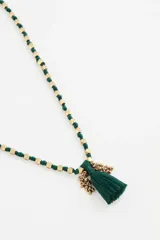 Collar largo con diseño de cuentas doradas intercaladas en un cordón negro, finalizado con una borla negra central.