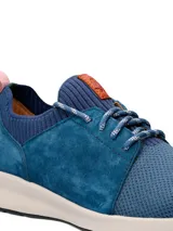 Championes casuales Hush Puppies modelo Spinal Knit, color azul marino. Presentan una combinación de tejido técnico transpirable en la puntera y laterales de cuero gamuzado. Incluyen cordones jaspeados, cuello tejido elástico y suela ergonómica de color blanco con tecnología Spinal para soporte postural.