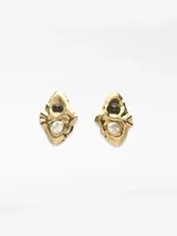 Pendientes metálicos con diseño en relieve de forma orgánica, decorados con una perla natural y una cuenta oscura. Poseen cierre de broche.