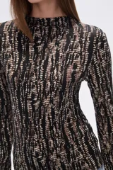 Remera de manga larga con cuello alto y estampado animal print en tonos marrones.