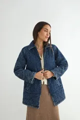 Chaqueta de denim azul con diseño acolchado en forma de rombos, cierre frontal con cremallera y bolsillos laterales.