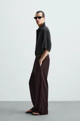Camisa de corte relajado confeccionada en tejido con mezcla de modal, con cuello solapa, manga corta y cierre frontal de botones.