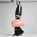 Bolso deportivo Puma Phase Small color salmón con logo blanco estampado. Tiene doble asa de mano, cierre superior con cremallera y bolsillo lateral de malla.