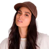 Gorra de béisbol con visera curva, confeccionada en cuero sintético de aspecto desgastado en color marrón. Presenta un pequeño aplique metálico con el logo de la marca en el lateral y cierre ajustable con hebilla metálica en la parte posterior.