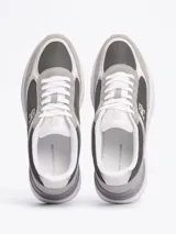 Zapatillas Tommy Hilfiger de diseño color block con paneles de malla, exterior e interior de poliéster, plantilla extraíble de poliuretano y caucho termoplástico, suela de EVA, panel metálico en el talón y monograma TH en la lengüeta y lateral.