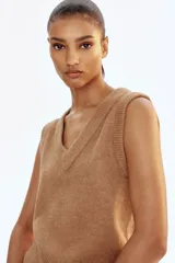 Chaleco corto de punto suave con escote en V, sisas y bajo acanalados.