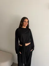 Conjunto de dos piezas de viscosa y poliéster color gris melange, compuesto por un buzo de manga larga y un pantalón largo de corte recto con lazo ajustable en la cintura.