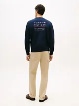 Buzo de cuello redondo color azul marino, de mangas largas con puños y cintura elásticos. Presenta el logo bordado de Tommy Hilfiger en el pecho.
