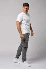 Pantalón cargo color beige de gabardina, con corte ajustado, bolsillos laterales con fuelle y puños elásticos en los tobillos.