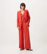 Chaleco de sastrería rojo con escote en V, sin mangas y cierre frontal con botones en contraste. Confeccionado en viscolino, de corte entallado y estilo elegante.