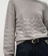 Suéter de punto color negro con cuello redondo y mangas largas. Presenta un diseño con franjas horizontales decoradas con lentejuelas del mismo tono en el cuerpo y las mangas.