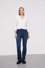 Pantalon jean de tiro alto con corte flare y terminación desflecada en el ruedo. Presenta un diseño clásico de cinco bolsillos con costuras en contraste.
