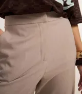 Pantalón de vestir color beige, de corte recto, confeccionado en crepé. Cuenta con cintura fija, bolsillos laterales tipo cuchillo y cierre frontal oculto.