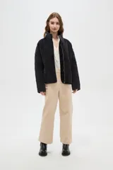 Campera de estilo bomber con diseño capitoneado en forma de rombos, color negro con efecto lavado. Presenta cuello alto, cierre frontal metálico y bolsillos laterales.