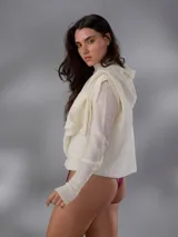 Saco largo de punto color blanco, confeccionado en 100% lana merino natural, con diseño jacquard de ramas, cuello alto, cierre frontal con pequeños botones y aberturas laterales.